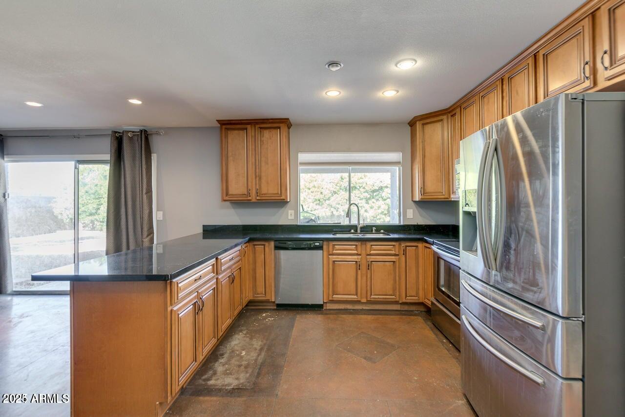 3832 East Bloomfield Road Phoenix, AZ 85032 - Photo 11 of 32 a kitchen with stainless steel appliances granite countertop a refrigerator and a sink