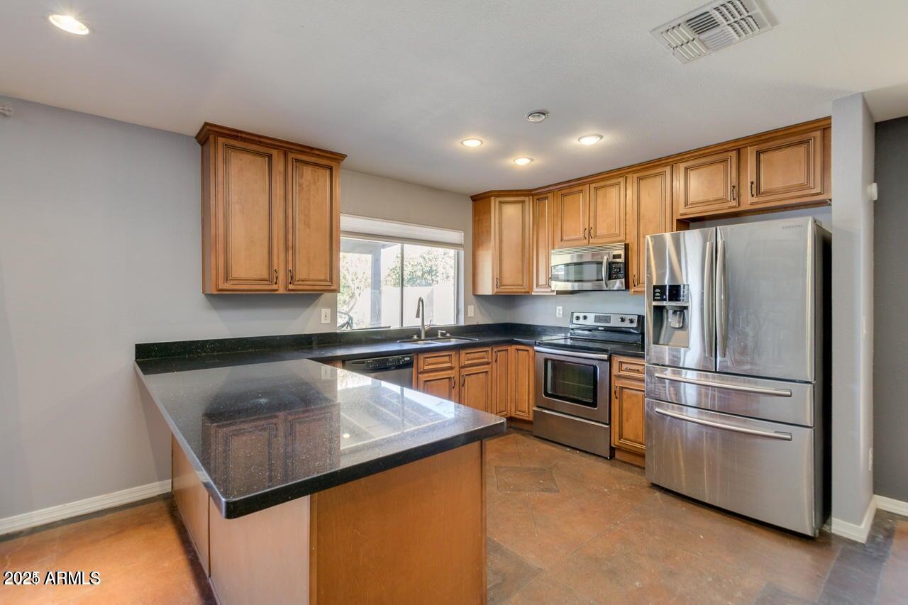 3832 East Bloomfield Road Phoenix, AZ 85032 - Photo 12 of 32 a kitchen with granite countertop stainless steel appliances a refrigerator sink and microwave