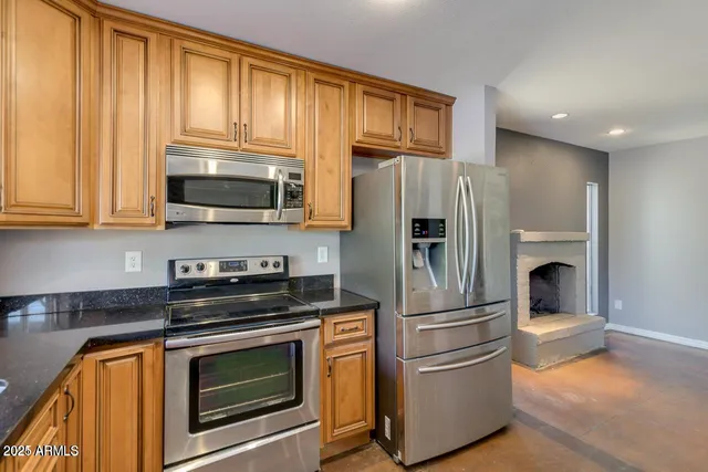 a kitchen with stainless steel appliances granite countertop a refrigerator stove and microwave