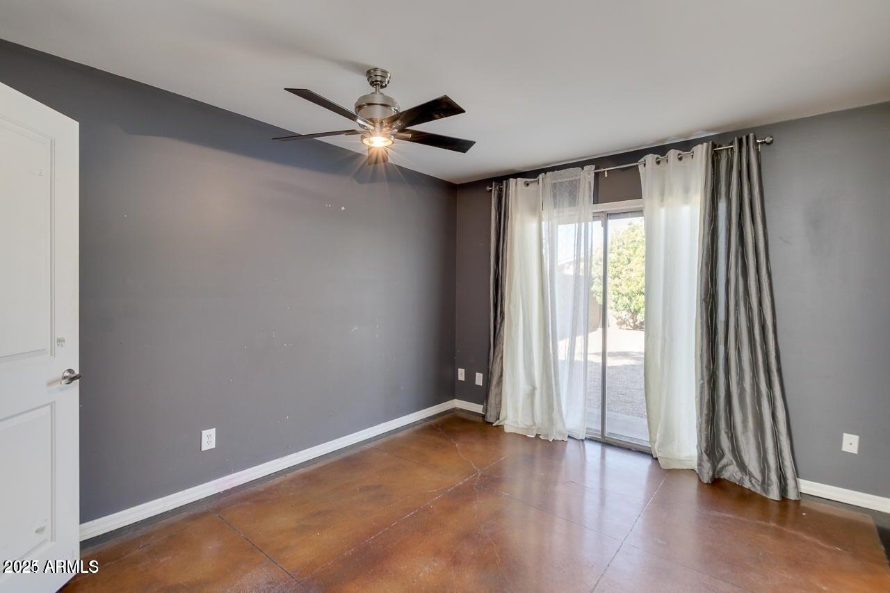 3832 East Bloomfield Road Phoenix, AZ 85032 - Photo 15 of 32 an empty room with wooden floor fan and windows