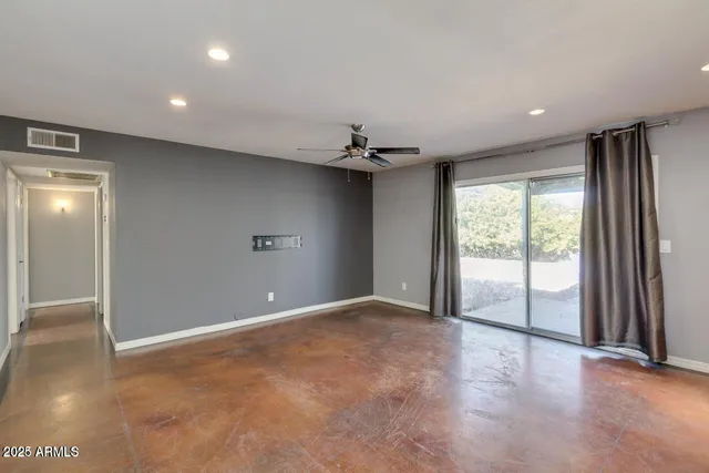a view of a livingroom with a ceiling fan and window