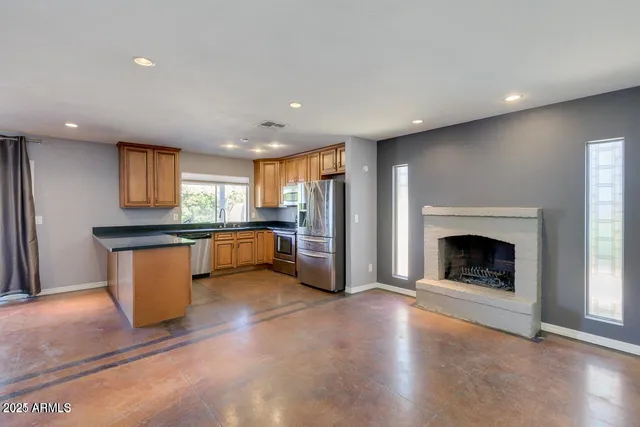 a view of kitchen with refrigerator and a fireplace