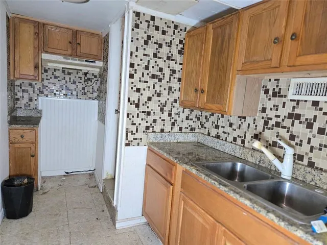 a kitchen with granite countertop a sink and a refrigerator