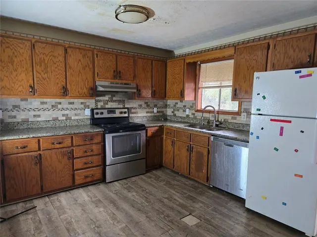 a kitchen with granite countertop a sink stainless steel appliances and cabinets