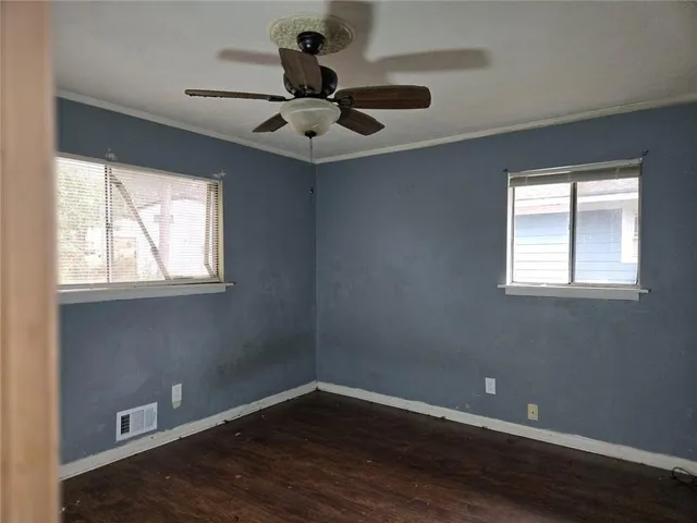 a view of a big room with wooden floor and windows