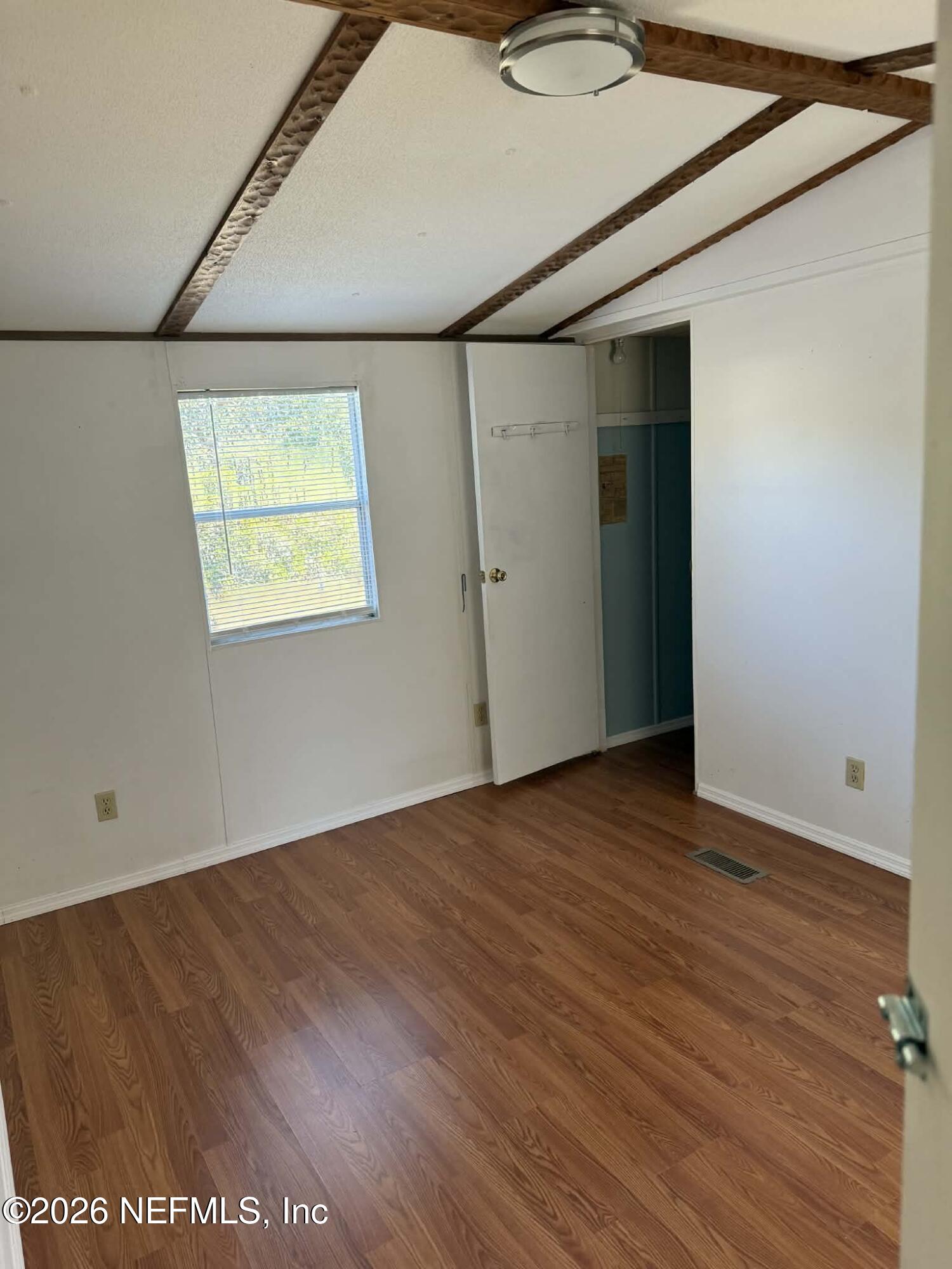 133 Sportsman Road Satsuma, FL 32189 - Photo 10 of 45 an empty room with wooden floor and windows