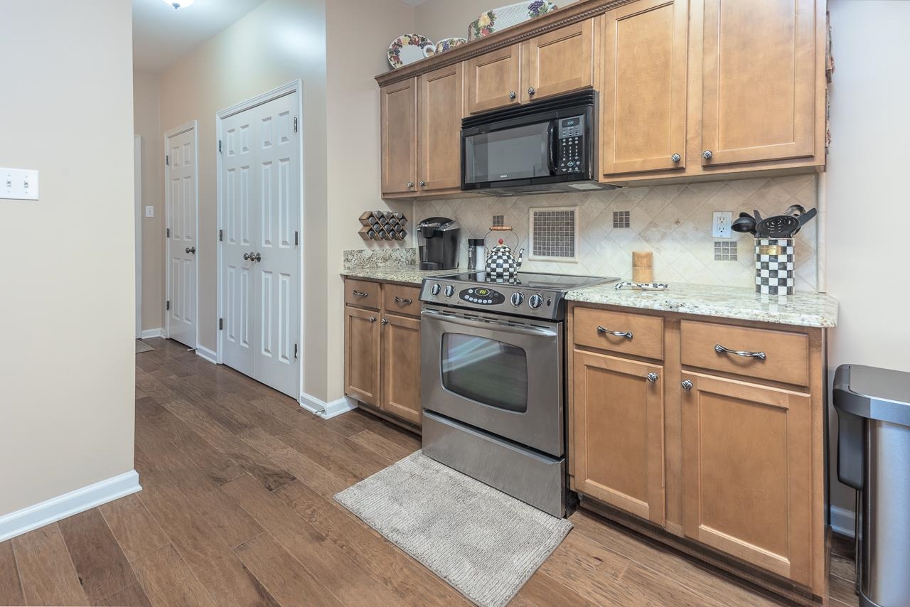 6031 Grayce Drive Bartlett, TN 38134 - Photo 11 of 31 a kitchen with stainless steel appliances granite countertop a stove a sink and a microwave