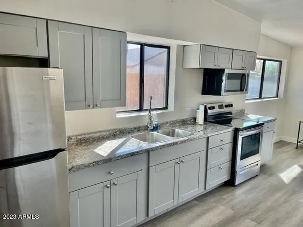 a kitchen with appliances a sink and cabinets