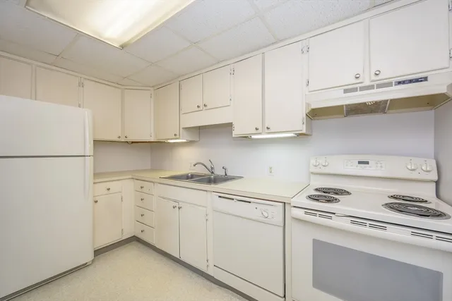 a kitchen with cabinets appliances a sink and a counter