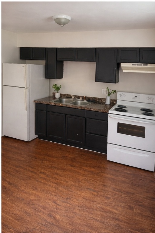 706 Denson Drive Austin, TX 78752 - Photo 3 of 5 a kitchen with stainless steel appliances granite countertop a stove a sink and a refrigerator