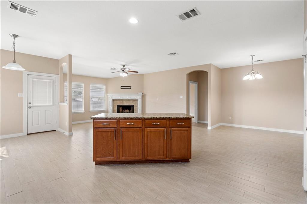 20224 Merlin Falcon Trail Pflugerville, TX 78660 - Photo 19 of 40 An open concept design seamlessly connects the kitchen and living spaces, perfect for gatherings.