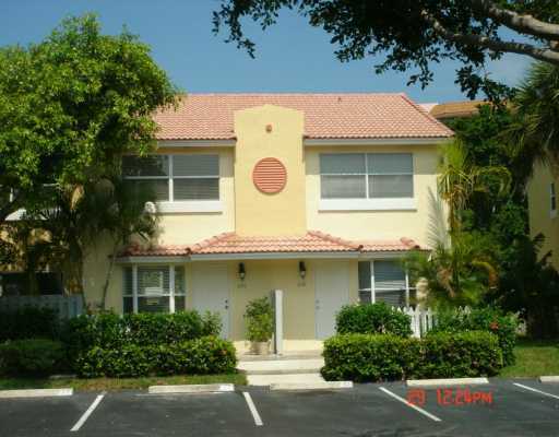 1068 Jeffery Street Boca Raton, FL 33487 - Photo 1 of 13 a view of a white house with large windows and a small yard