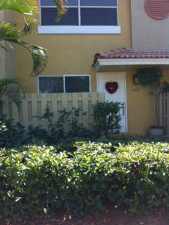 1068 Jeffery Street Boca Raton, FL 33487 - Photo 2 of 13 a front view of a house with a yard