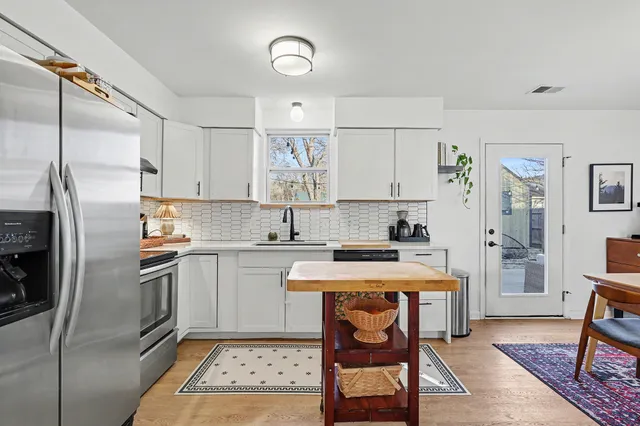 a kitchen with a stove a refrigerator and a dining table