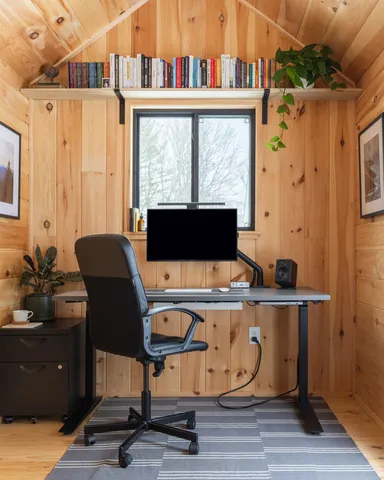 a view of a workspace with furniture and a window