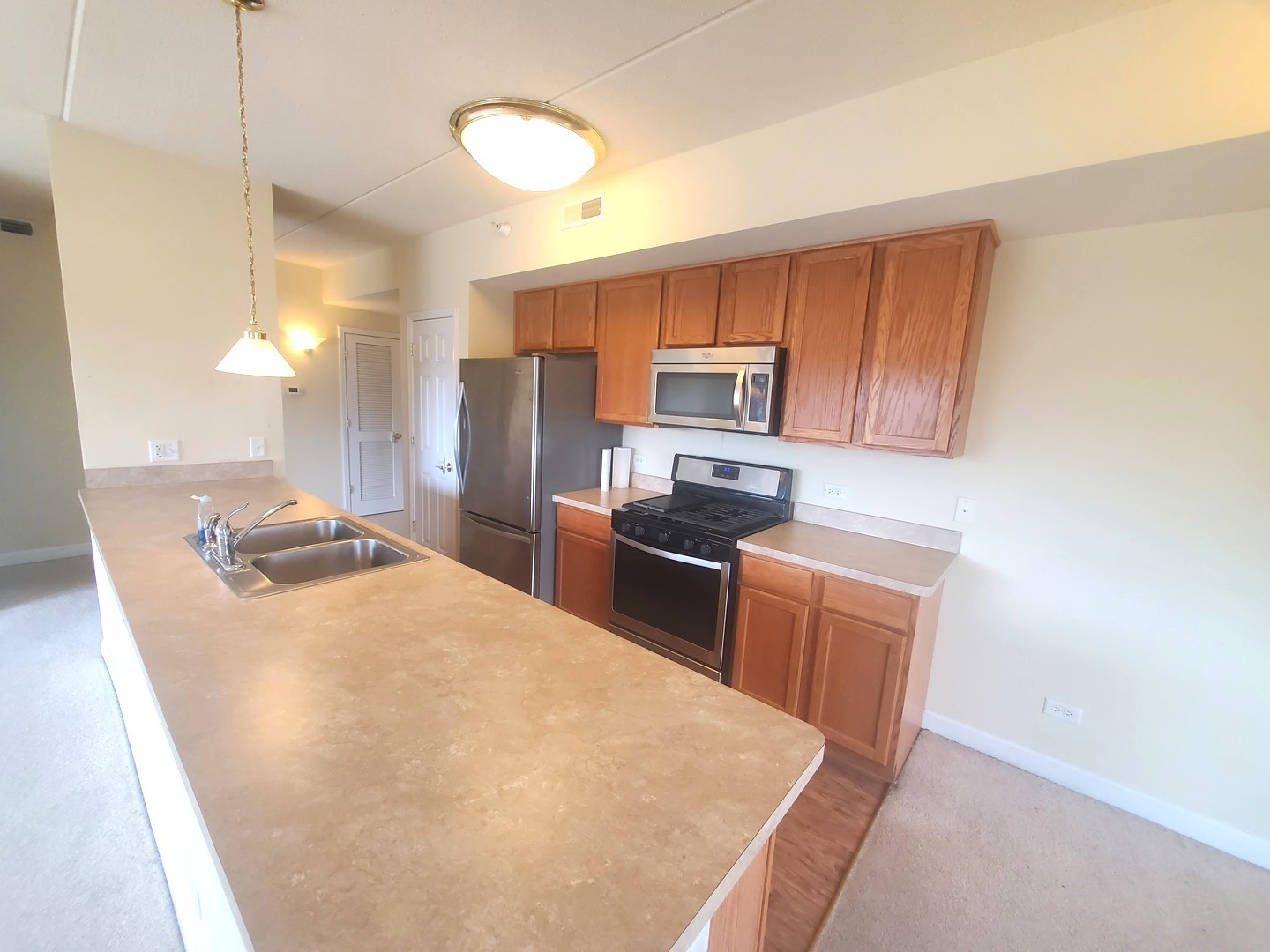 77 North Wolf Road, Unit 310 Northlake, IL 60164 - Photo 3 of 13 a kitchen with stainless steel appliances a refrigerator stove microwave and sink