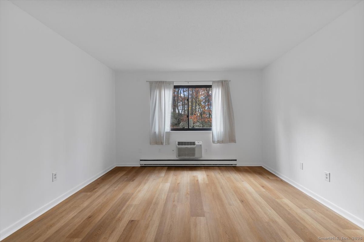 2998 Madison Avenue, Unit C Bridgeport, CT 06606 - Photo 18 of 24 an empty room with wooden floor and windows