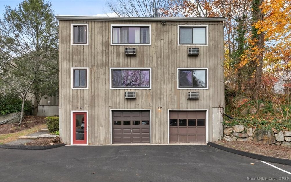 2998 Madison Avenue, Unit C Bridgeport, CT 06606 - Photo 3 of 24 a front view of a building with glass windows and a road