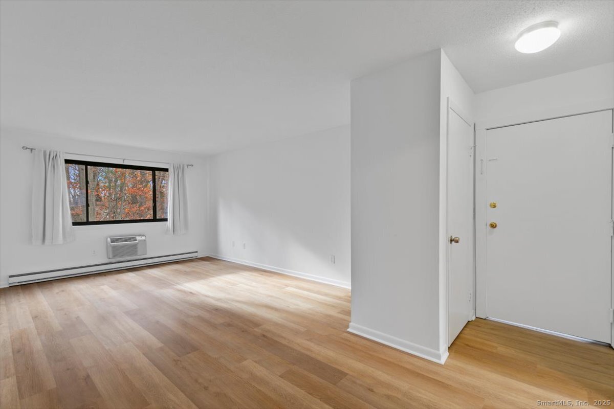2998 Madison Avenue, Unit C Bridgeport, CT 06606 - Photo 5 of 24 a view of an empty room with wooden floor and a window