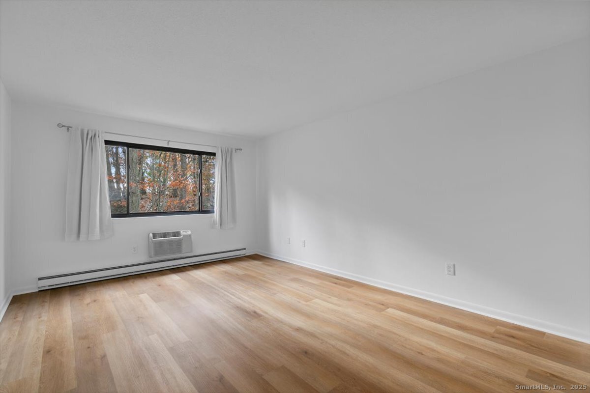 2998 Madison Avenue, Unit C Bridgeport, CT 06606 - Photo 6 of 24 an empty room with wooden floor and windows