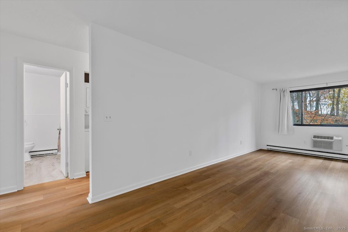 2998 Madison Avenue, Unit C Bridgeport, CT 06606 - Photo 7 of 24 a view of an empty room with wooden floor and a window