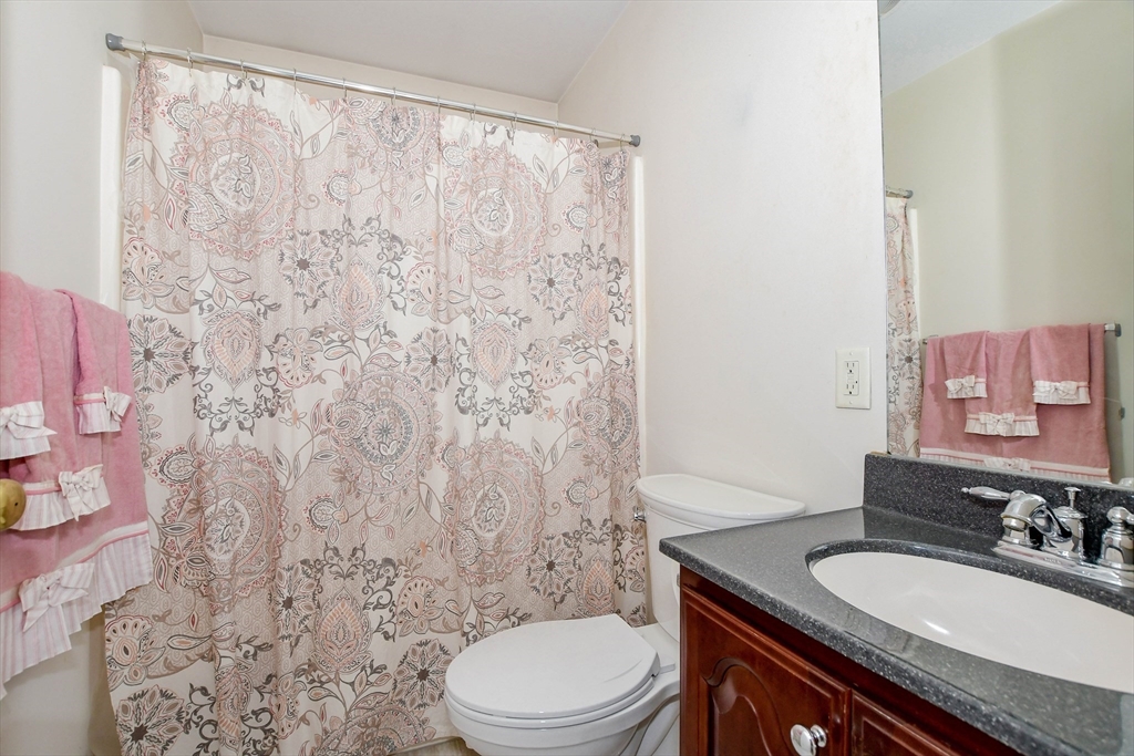 57 Harvest Circle Wareham, MA 02576 - Photo 25 of 39 a bathroom with a granite countertop sink toilet a mirror and shower curtain