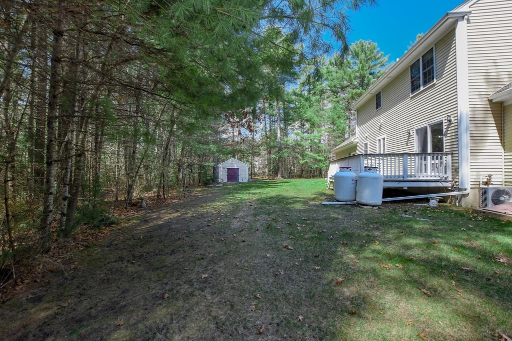 57 Harvest Circle Wareham, MA 02576 - Photo 35 of 39 a view of a backyard with large trees and wooden fence