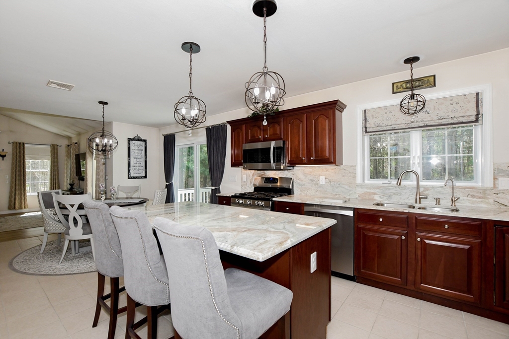 57 Harvest Circle Wareham, MA 02576 - Photo 5 of 39 a view of a dining room and kitchen with a table chairs a workspace