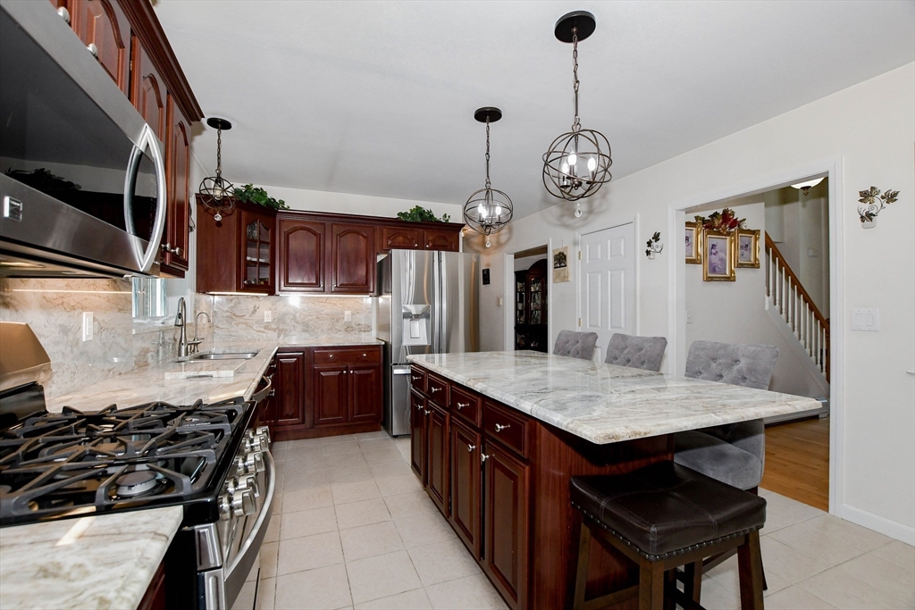 57 Harvest Circle Wareham, MA 02576 - Photo 6 of 39 a kitchen with granite countertop a stove a sink a refrigerator and a wooden floors