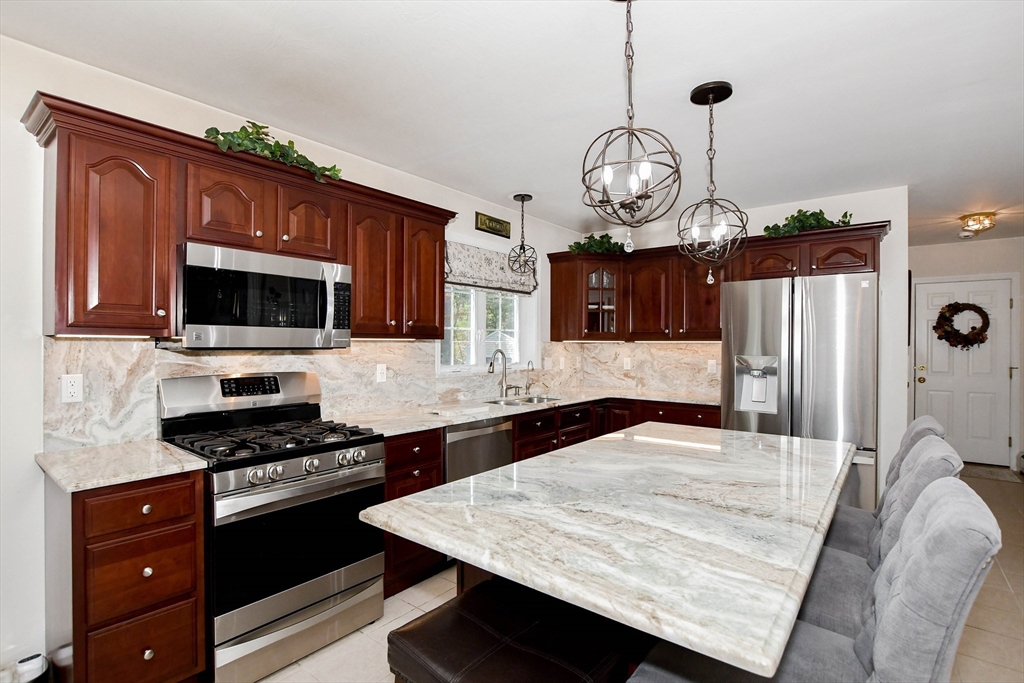 57 Harvest Circle Wareham, MA 02576 - Photo 9 of 39 a kitchen with stainless steel appliances granite countertop a stove oven and a microwave with cabinets