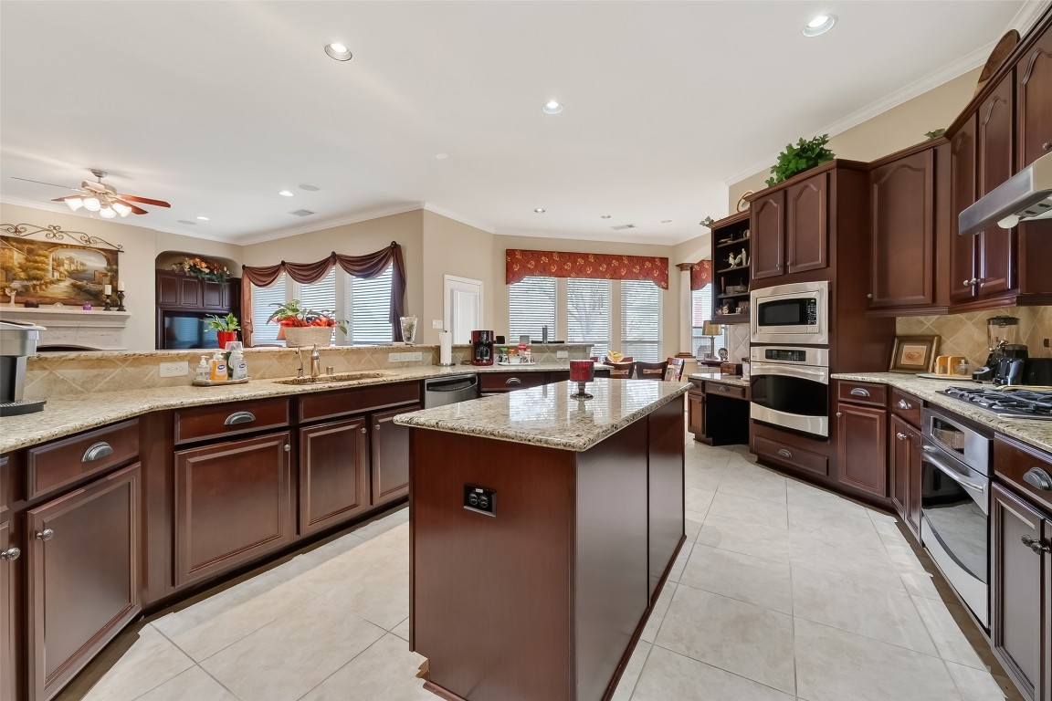 18622 Yorkshire Manor Court Spring, TX 77379 - Photo 22 of 41 a kitchen with stainless steel appliances granite countertop a sink counter space cabinets and a large window