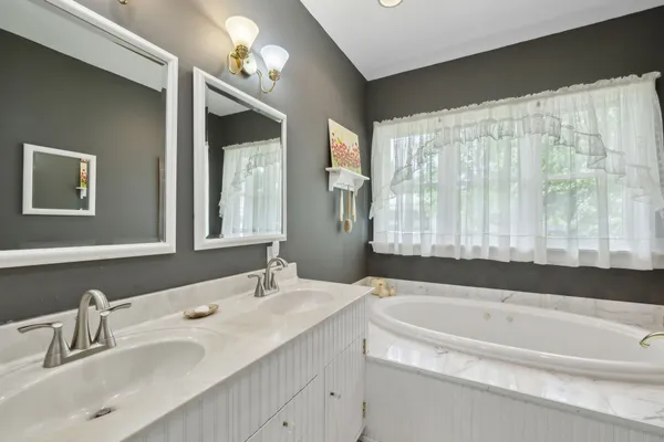 a en suite bathroom with a double vanity sink and a mirror