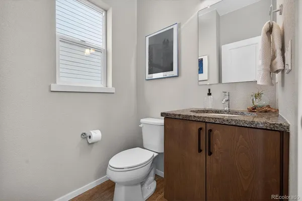 a bathroom with a granite countertop toilet sink and mirror