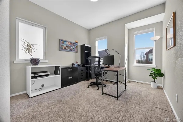 a view of a workspace with furniture and a window