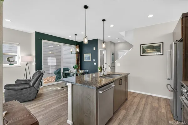 a kitchen with granite countertop a sink a counter top space and living room view