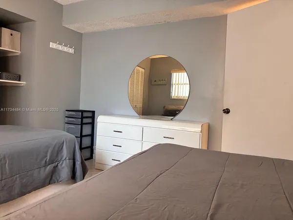 a bedroom with a bed and a mirror on dresser