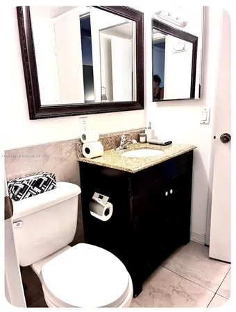 a bathroom with a toilet a sink and mirror