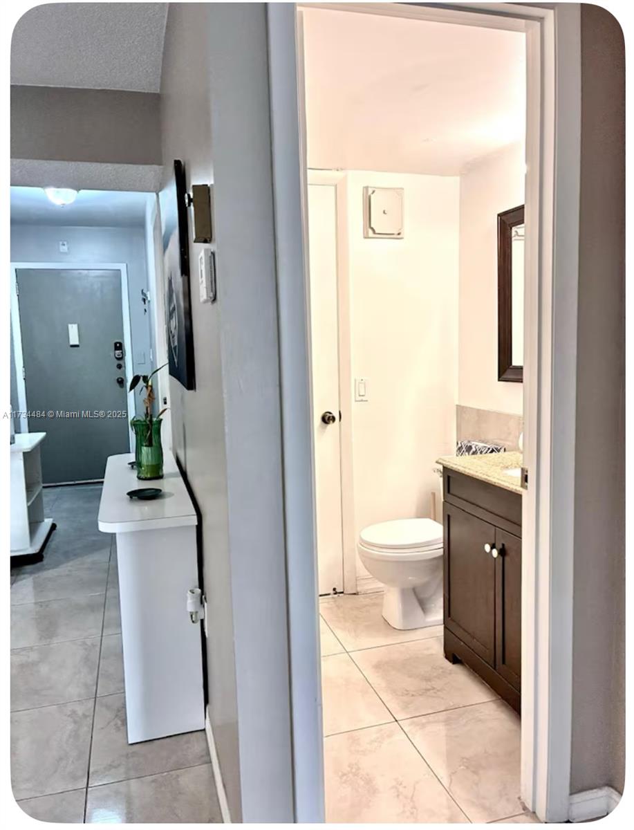 201 178th Drive, Unit 331 Sunny Isles Beach, FL 33160 - Photo 18 of 27 a bathroom with a toilet a sink and mirror