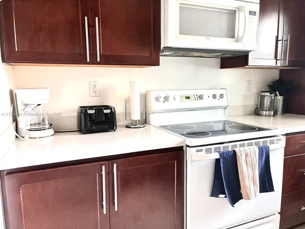 a kitchen with stainless steel appliances a stove a sink a microwave a refrigerator and cabinets