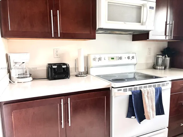 a kitchen with stainless steel appliances a stove a sink a microwave a refrigerator and cabinets