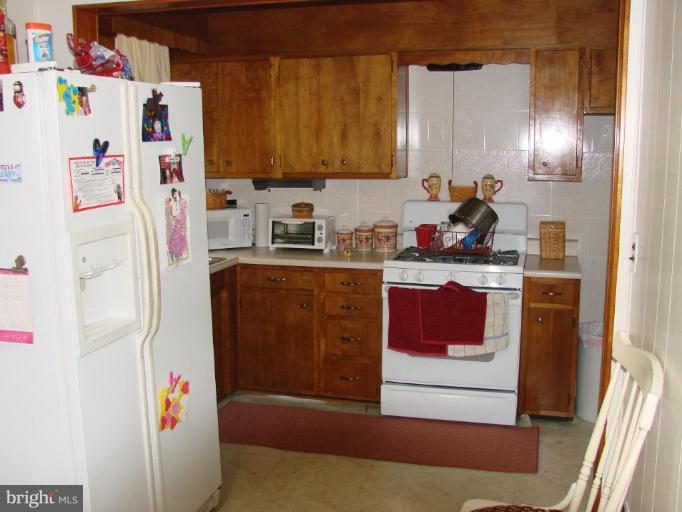 3002 Ritchie Avenue Sparrows Point, MD 21219 - Photo 8 of 15 a kitchen with a refrigerator a stove a sink and wooden floor