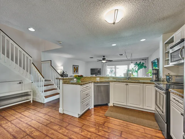 a living room with furniture and a dining table with kitchen view