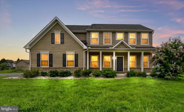 a front view of a house with porch and garden