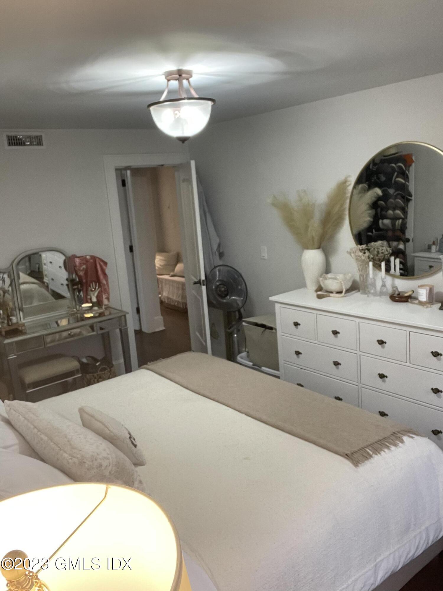 60 Weaver Street, Unit 2 Greenwich, CT 06831 - Photo 17 of 20 a bedroom with a bed and a chandelier
