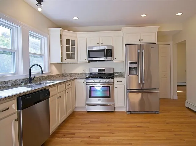 a kitchen with stainless steel appliances granite countertop a refrigerator and a stove top oven
