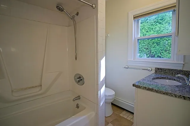 a bathroom with a granite countertop sink a toilet and shower