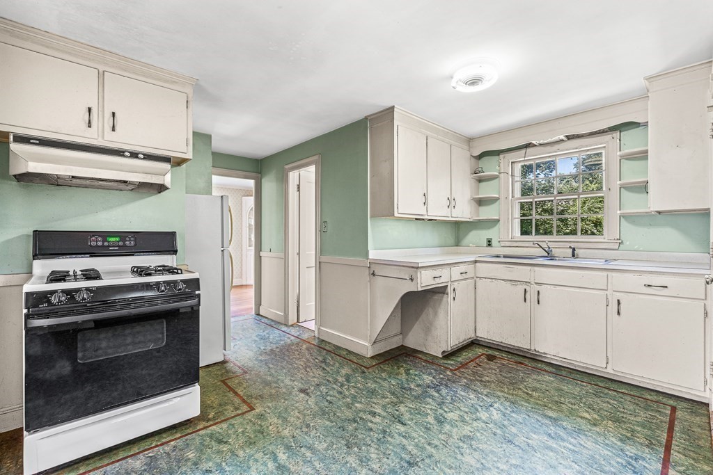 7 Spring Street Lexington, MA 02421 - Photo 8 of 25 a kitchen with granite countertop a stove a sink and a refrigerator