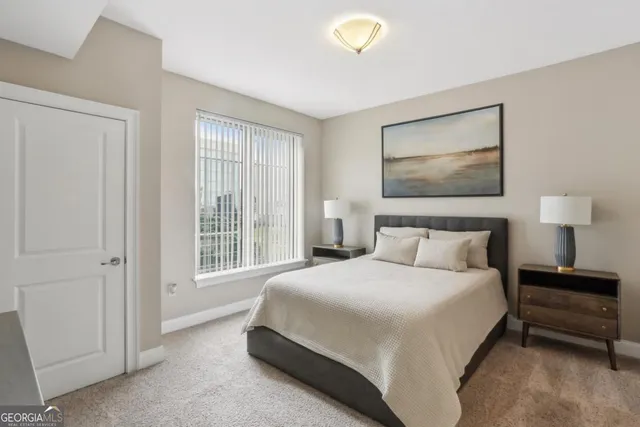 a bedroom with a bed and a lamp on dresser