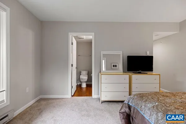 a bathroom with a granite countertop sink toilet and mirror