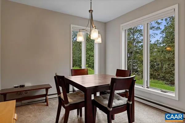 a dining room with furniture a chandelier and wooden floor